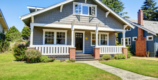 Clapboard siding house exterior. Large entance porch with brick